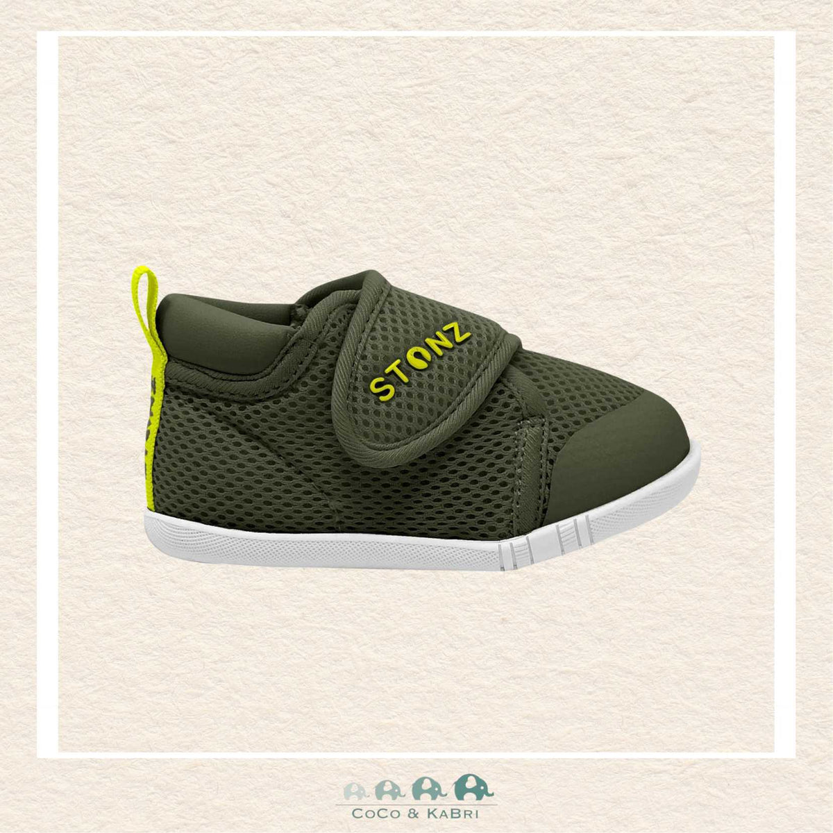 Green children's shoe with a strap on a beige background