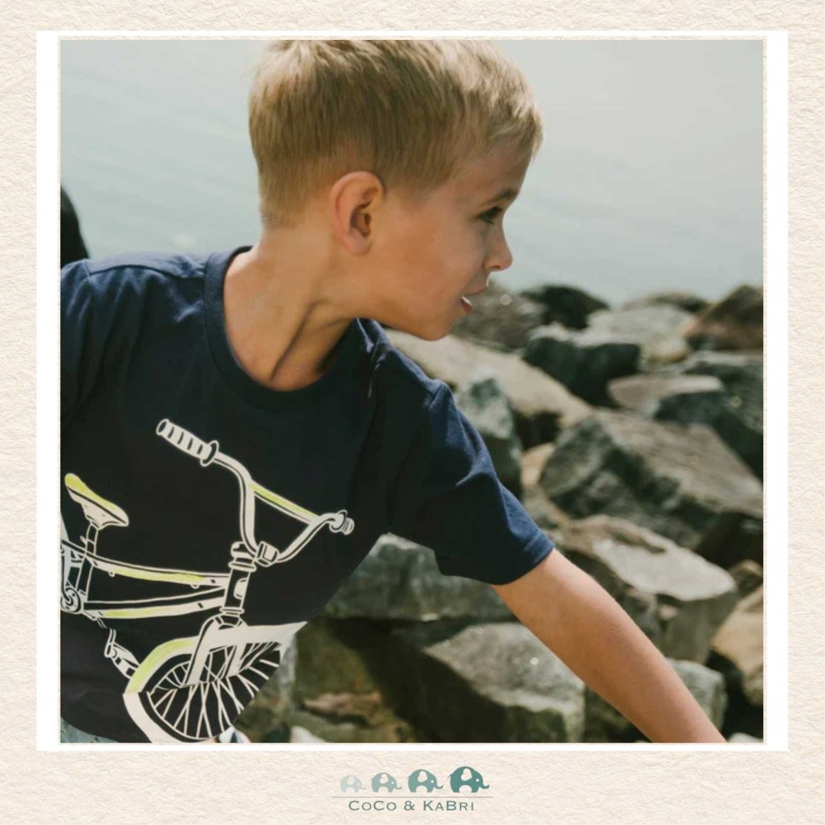 🇨🇦 Deux Par Deux: Organic Cotton Jersey T-Shirt With Bike Print Dark Blue, on a boy standing on rocks, CoCo & KaBri Children's Boutique, Brooks Alberta