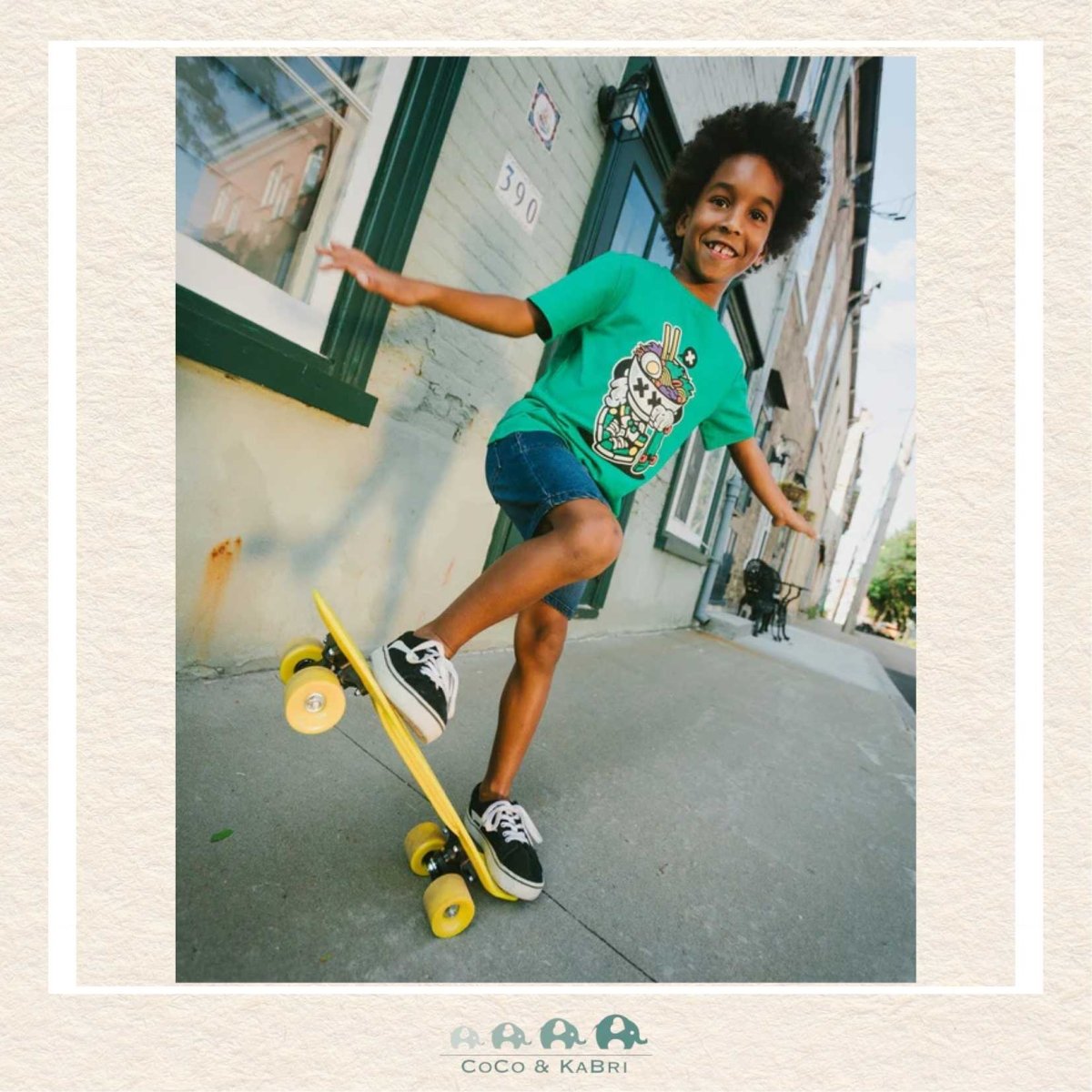 Child skateboarding on a sidewalk with a building in the background