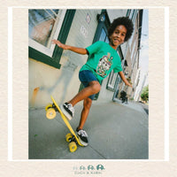 Child skateboarding on a sidewalk with a building in the background