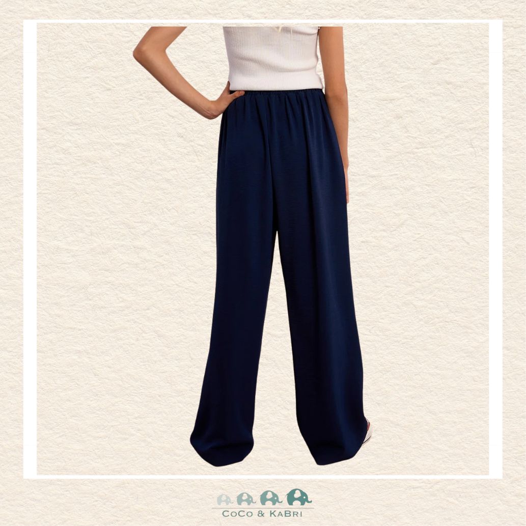 Back view of the model in the Molly Bracken navy pants, demonstrating the clean tailoring and the relaxed yet polished aesthetic of the flowing design