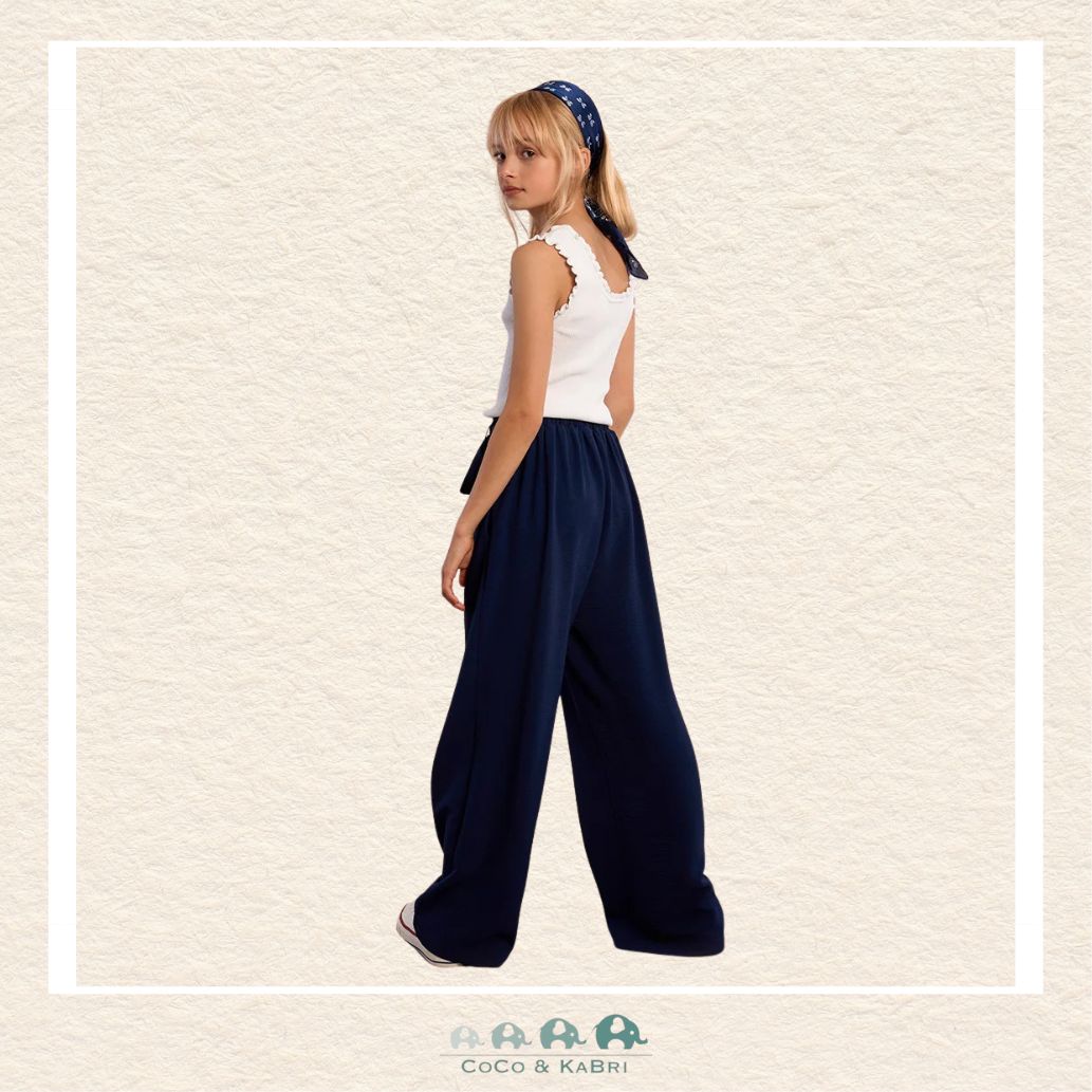 Back view of the model in the Molly Bracken navy pants, demonstrating the clean tailoring and the relaxed yet polished aesthetic of the flowing design