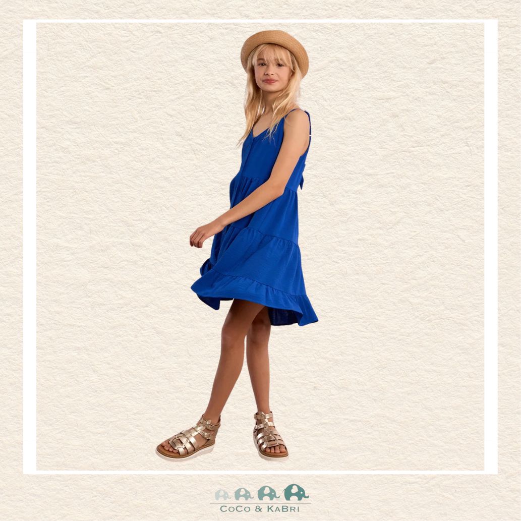 Side profile of the model in the cobalt blue woven dress, highlighting the airy ruffled tiers and the perfect fit of the thin adjustable straps