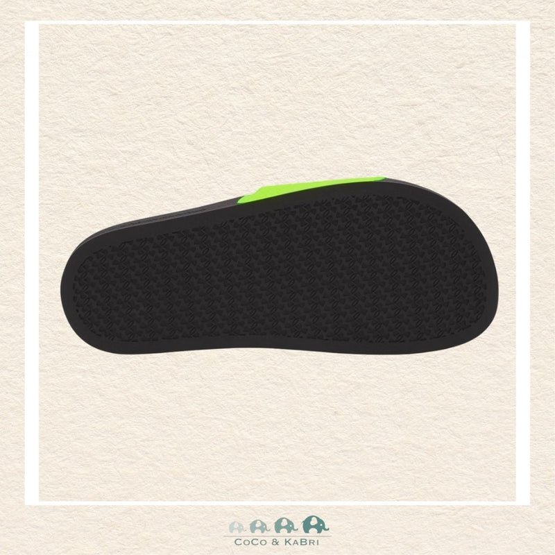 Black sandal sole with green accent on a beige background